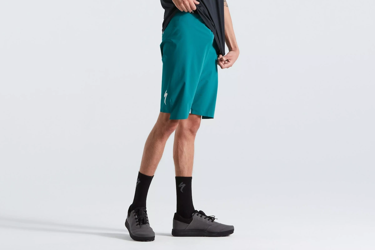 Vista lateral del Pantalon corto de trail marca Specialized para hombre de color Green Teal, diseño y estilo premium